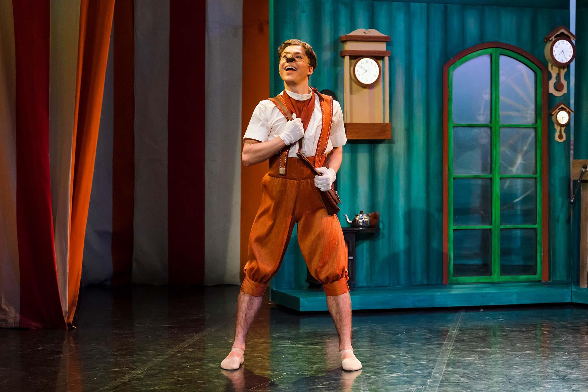 Pinocchio is proud as he is about to go to school with a satchel across one shoulder and a smile on his face